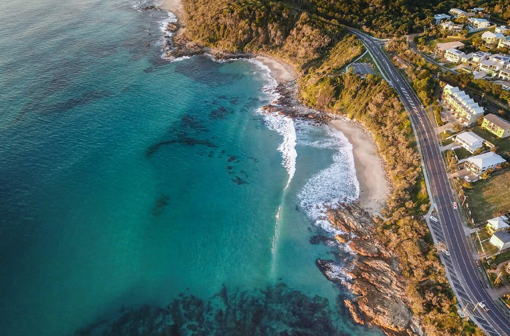 Aerial view of the ocean next to the road